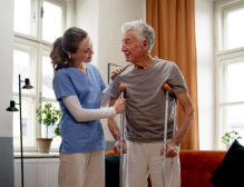 caregiver assisting the elderly man