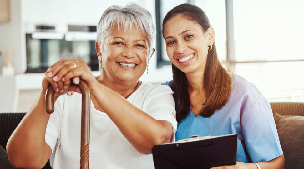 caregiver and elderly woman sitting in the sofa