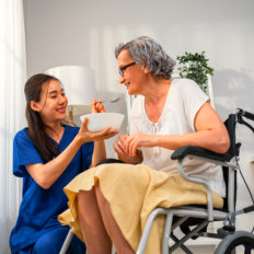 caregiver feeding the elderly woman