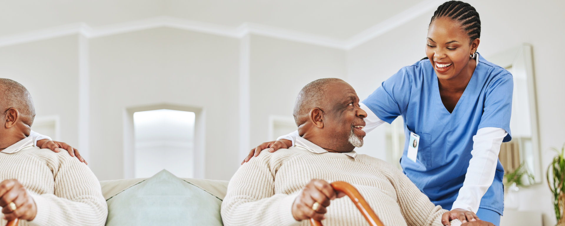 elderly man holding a cane with his caregiver