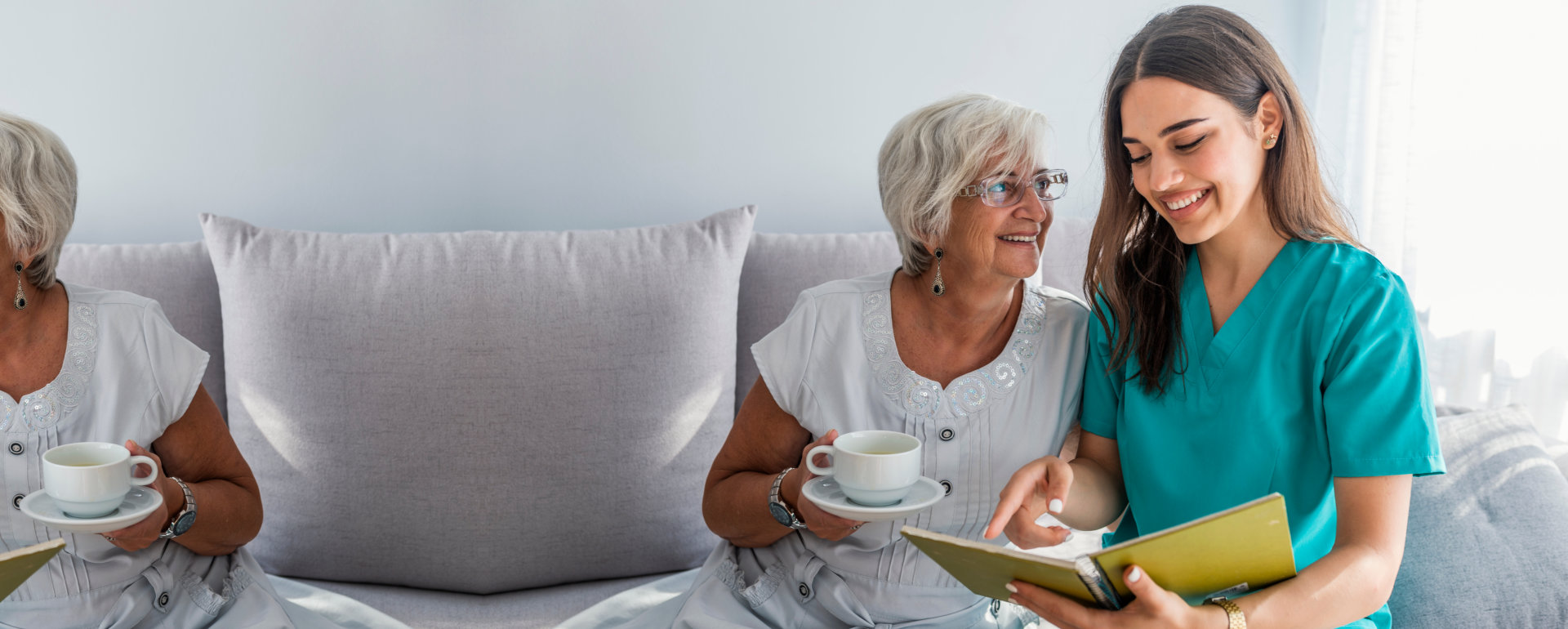 caregiver and elderly woman looking at the book