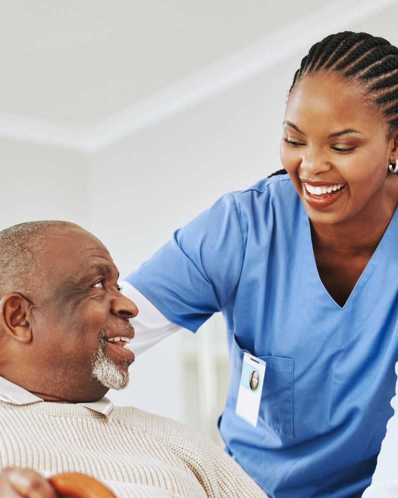 elderly man holding a cane with his caregiver