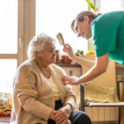 caregiver combing the elderly woman's hair