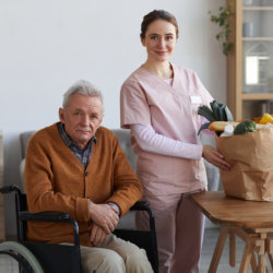 elderly man and caregiver holding a grocery bag