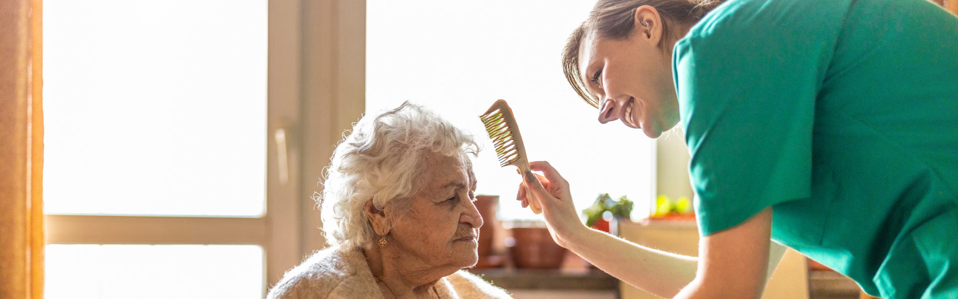 caregiver combing the elderly woman's hair