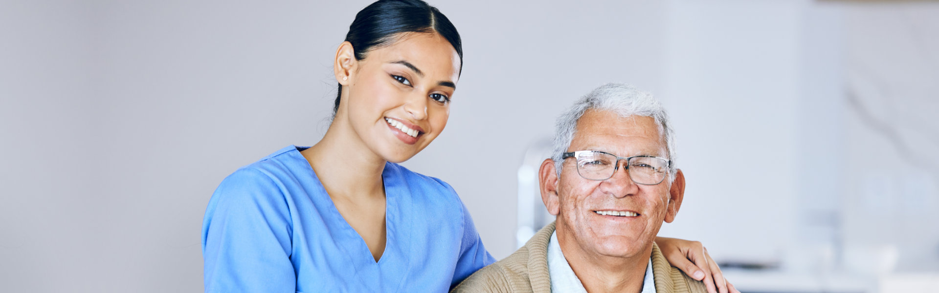 healthcare aide and elderly woman wearing glasses