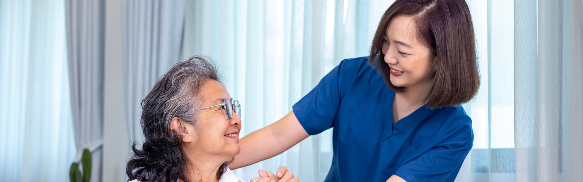 caregiver and elderly woman looking at each other